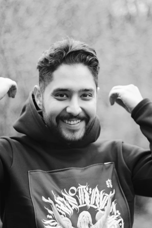 a man with a funny smile standing in front of trees