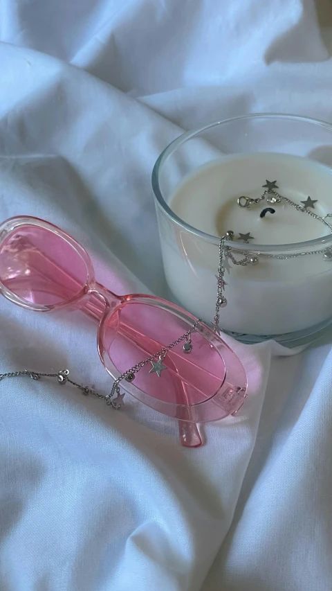 a table with a drink and pink sunglasses on top of it