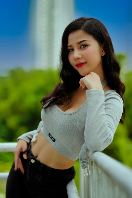 an asian girl in a gray shirt poses for the camera