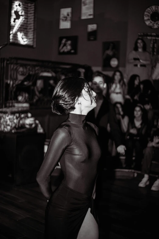 a woman in the dark with a large crowd watching