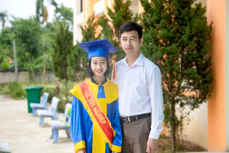 there is a man in a graduation gown and woman in dress clothes