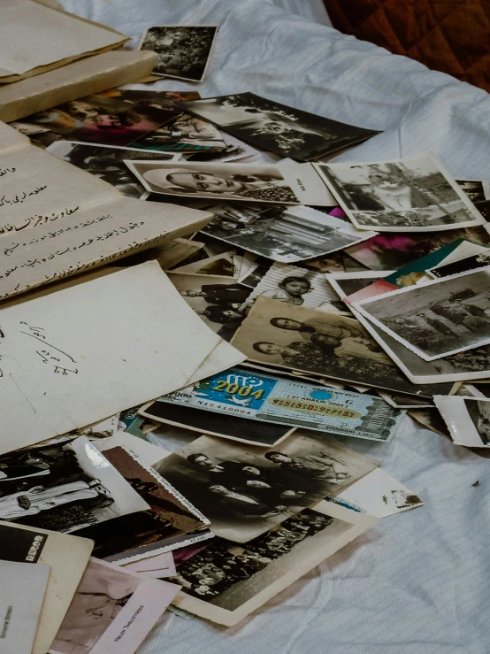 many pographs are lying on a bed covered in old mail