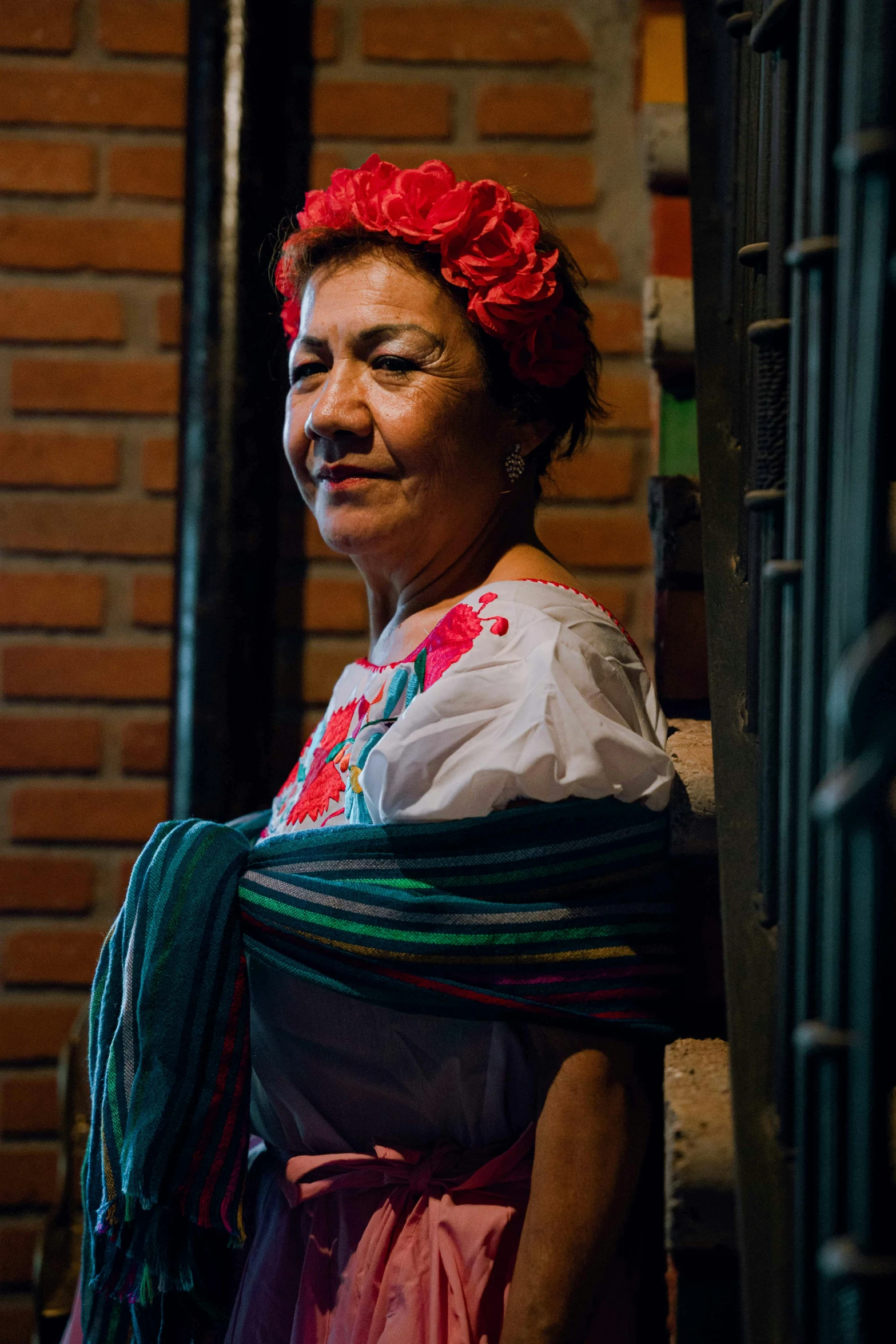 a woman with a brightly colored dress and a red flower in her hair