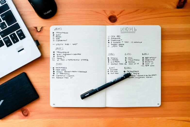 notebook with two tasks displayed on wooden table