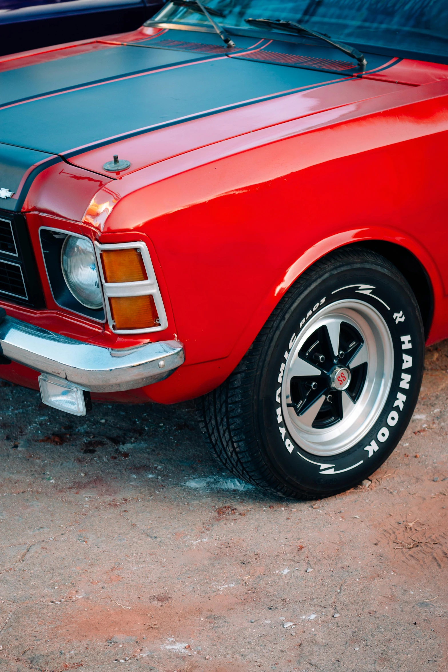 the back end of an old mustang parked in the dirt