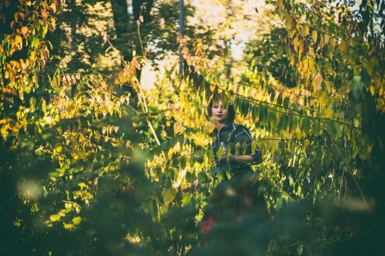 an adult woman standing in the middle of a lush green field