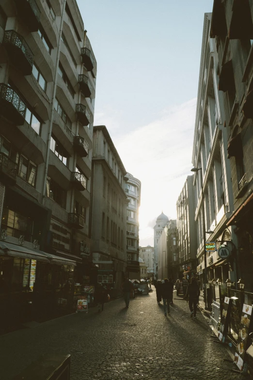 people walk in the city on a cobbled street