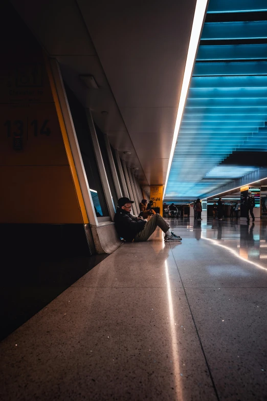 a person sits on the ground in an underground corridor