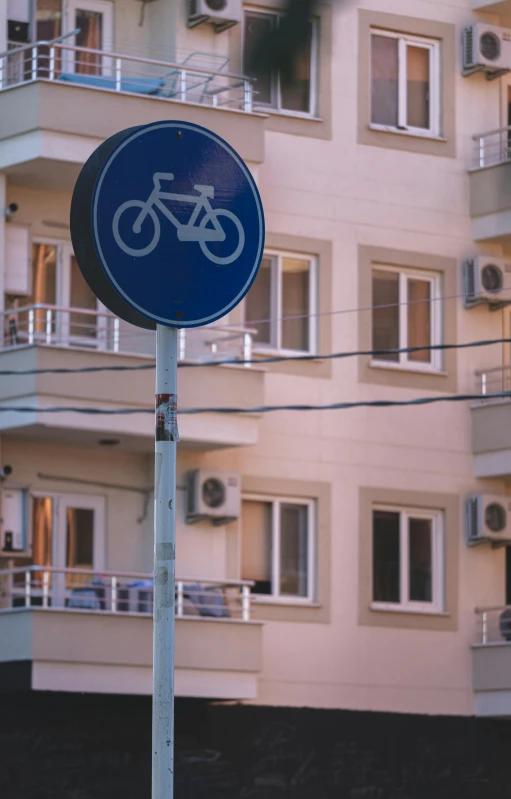 a bike street sign in front of an apartment building