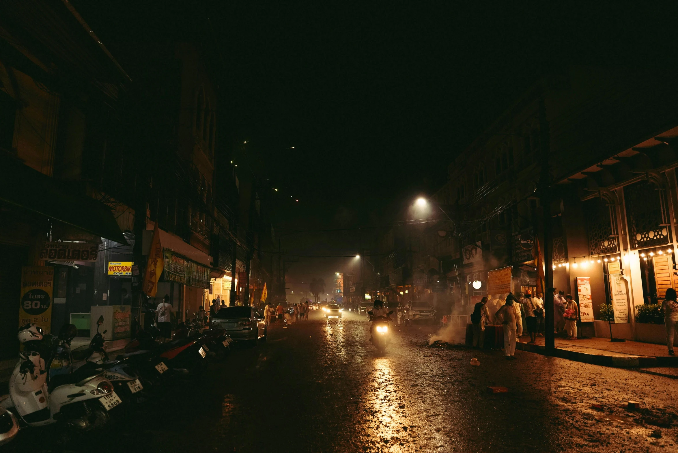 a city street filled with lots of traffic under a dark sky