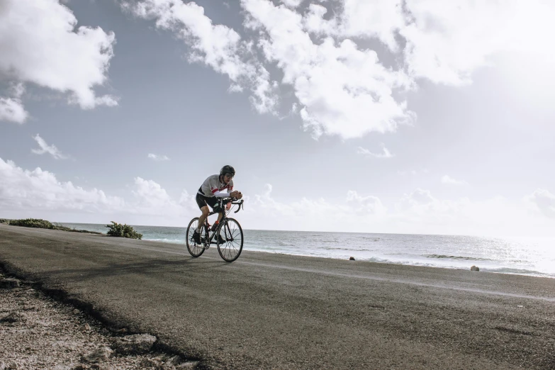 a man is riding his bike along a road next to the water