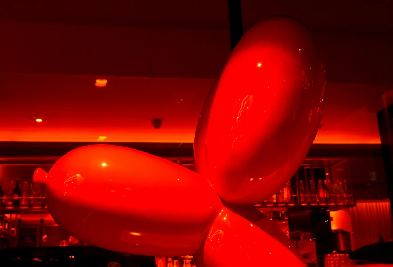 three balloon like shapes suspended over a table