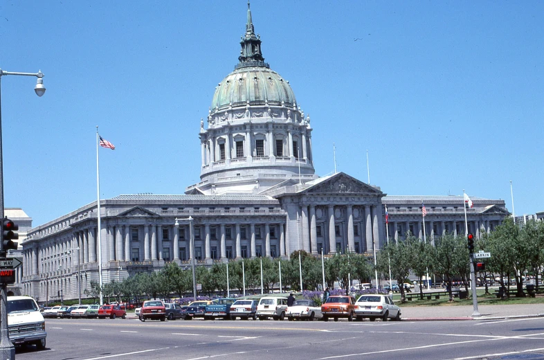 several cars sit parked in front of the california state capitol building