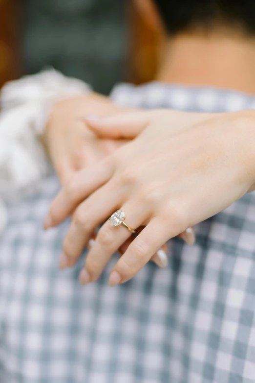 woman holding man's hand while wearing gold ring