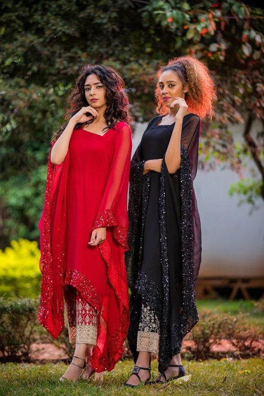 two beautiful ladies dressed in ethnic clothing posing for the camera