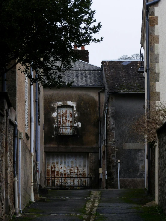 a narrow alleyway with an old building on the other side