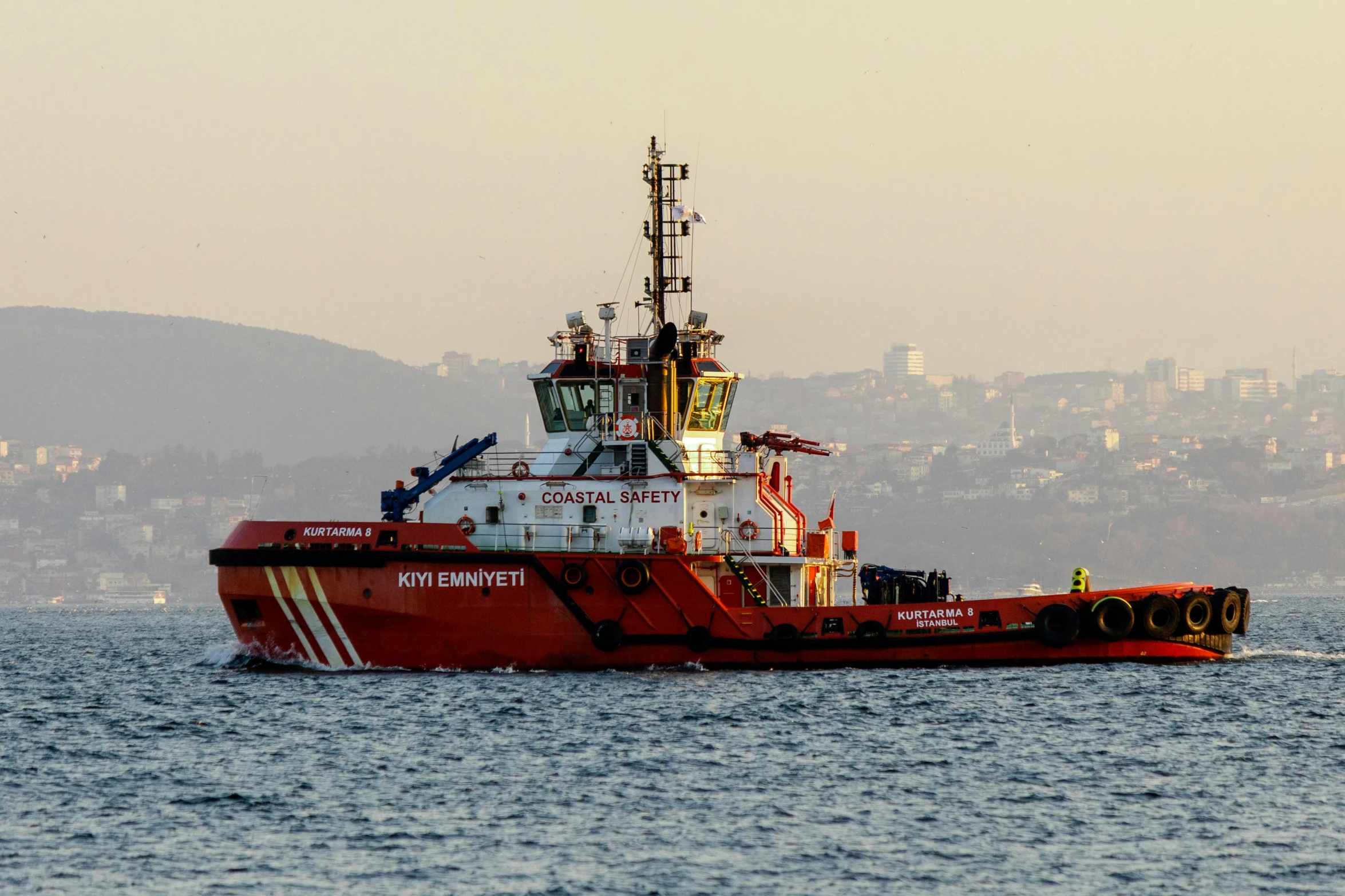 the red boat is headed towards the harbor