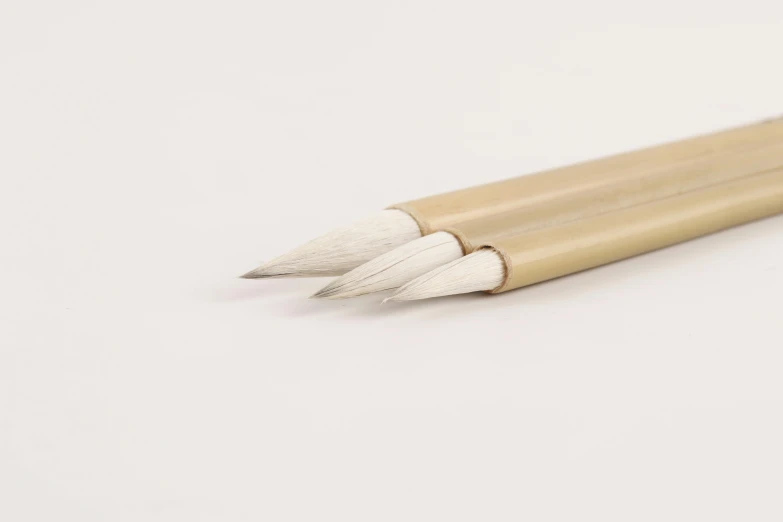 three pens sitting on top of a white table