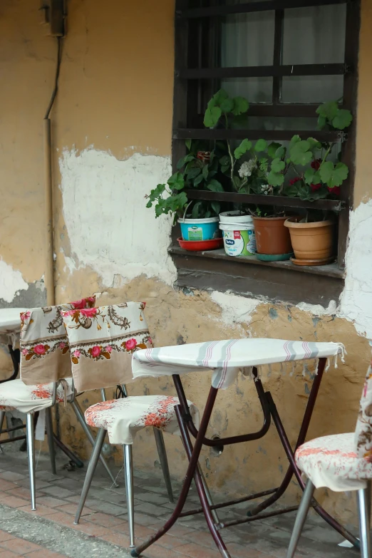 three empty patio tables with chairs on brick walkway