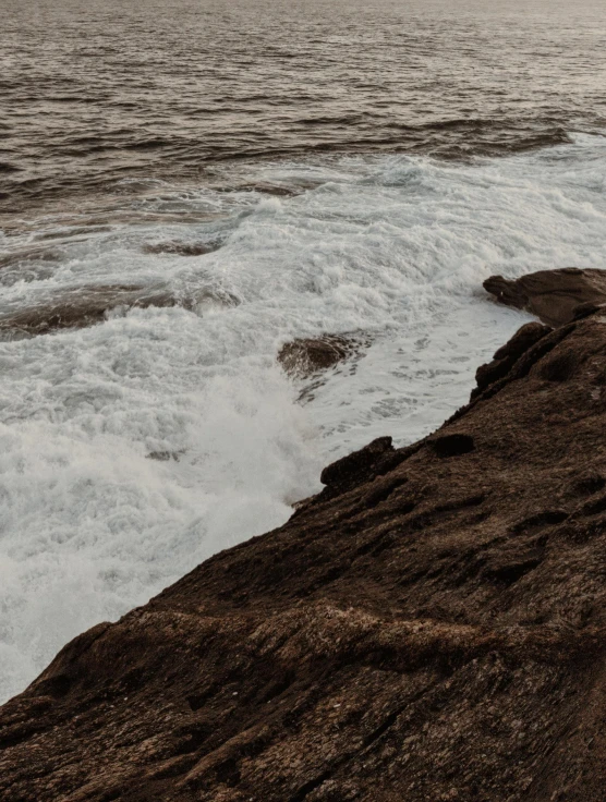 there is waves and rocks on the beach