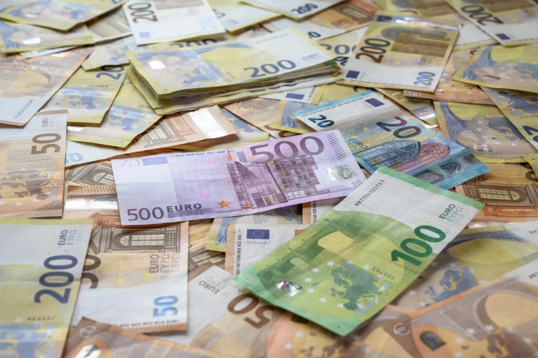 a pile of euros bill in front of another bunch of hundred euros