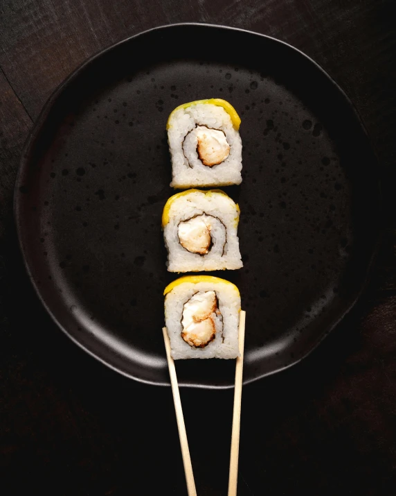 the sushi served with two wooden skewers