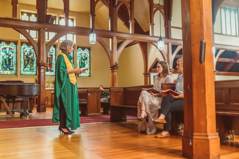 a woman stands in a church as another looks on