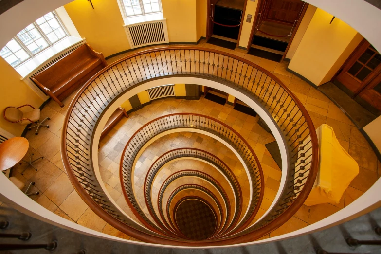 a spiral stair case in a room with many windows