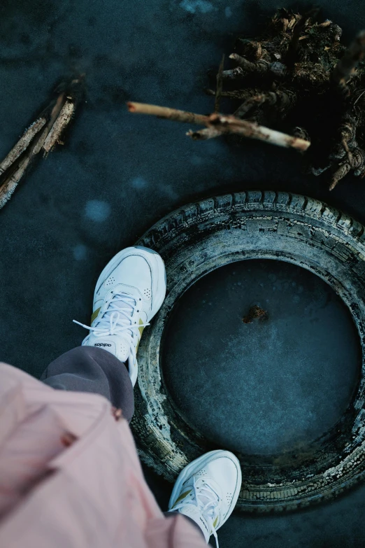 a person standing on top of a concrete slab near a flower pot