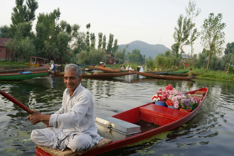 a man rows a boat with several other boats
