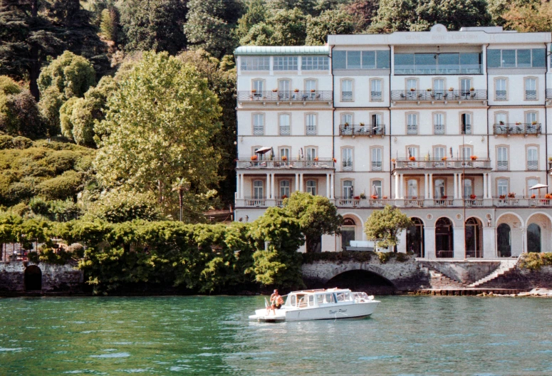 a house with people looking at it from the water