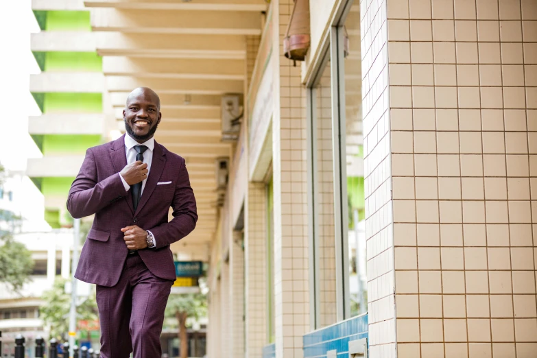 an african american man in a purple suit walking down the street