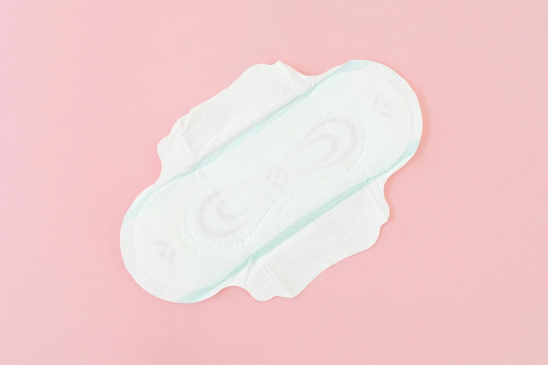 a pair of sanitary pads sitting on top of a pink surface