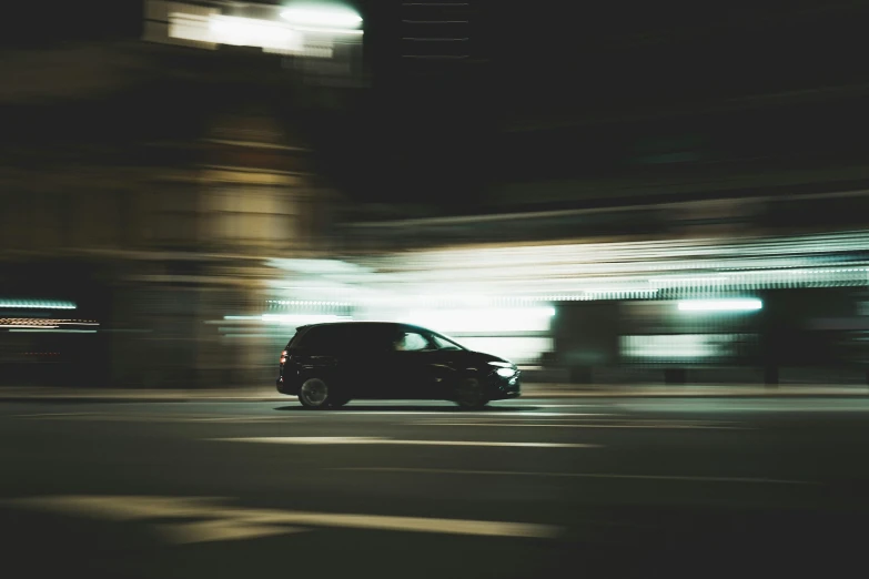 a car on a street at night with buildings in the background