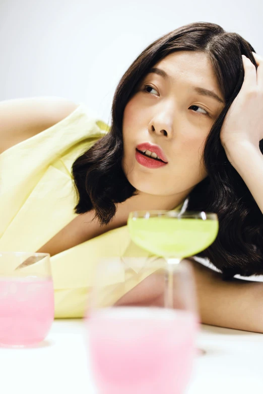 an attractive lady posing in front of different colored drinks