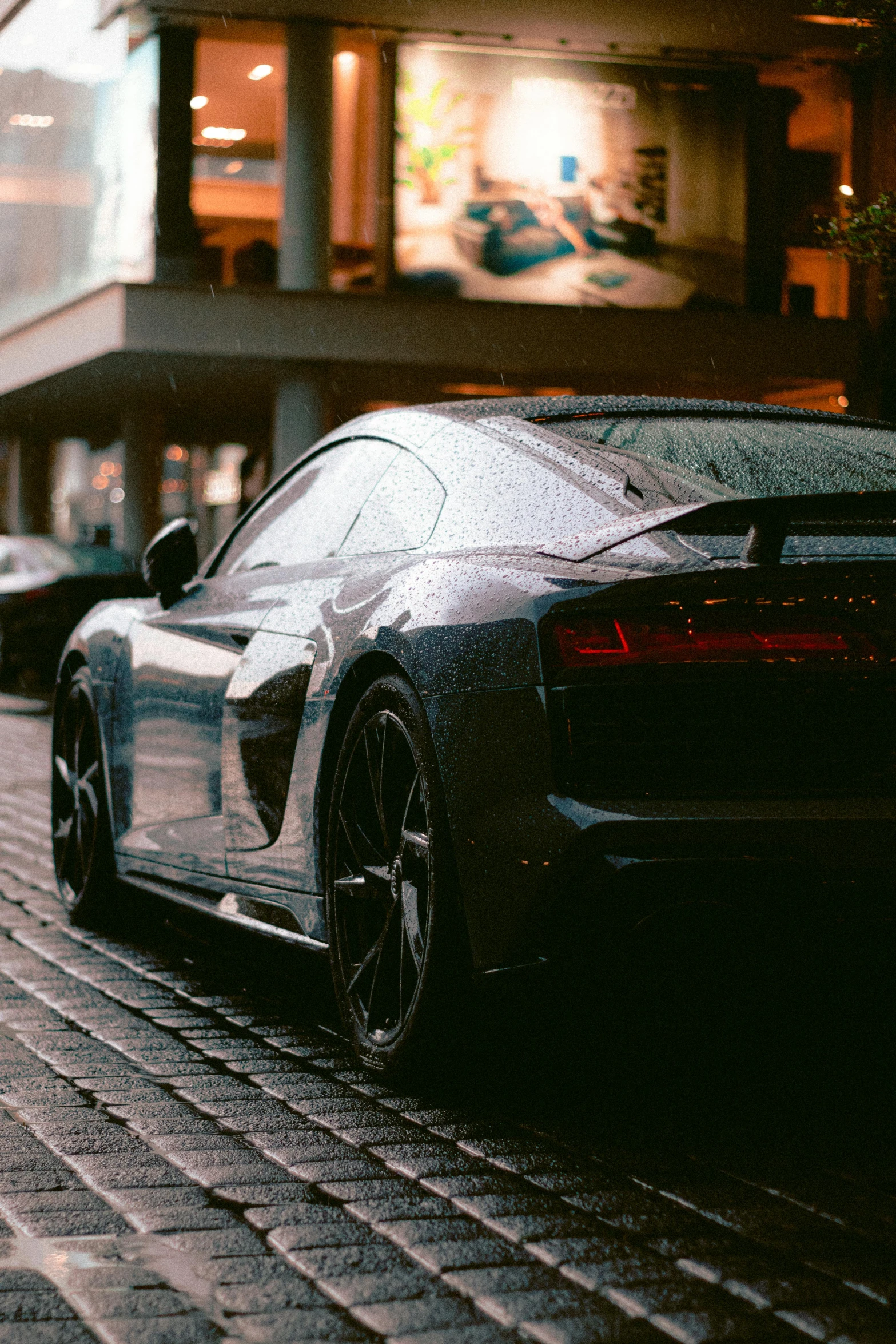 cars are parked along the sidewalk in front of shops