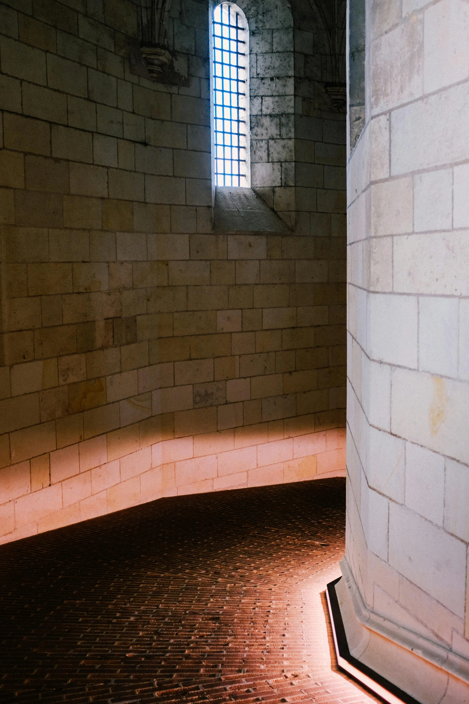 a brick floor with a window in the wall