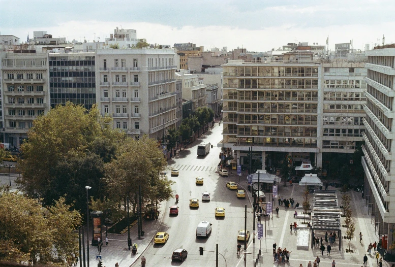 people walking on the street next to tall buildings