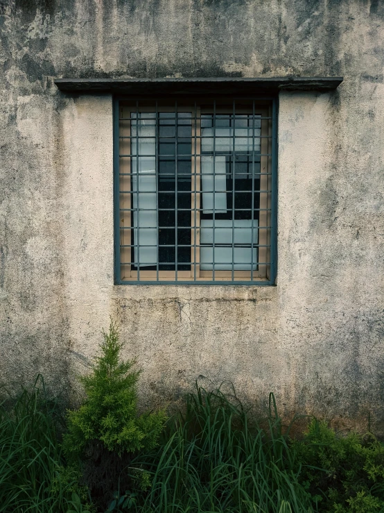 an old window on the side of a white stucco building