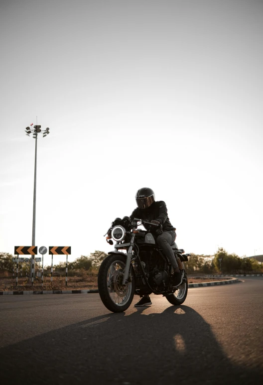 a man riding a motorcycle on a rural road