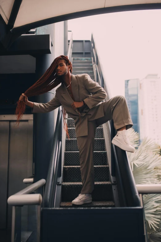 the man is standing on the escalator holding a scarf