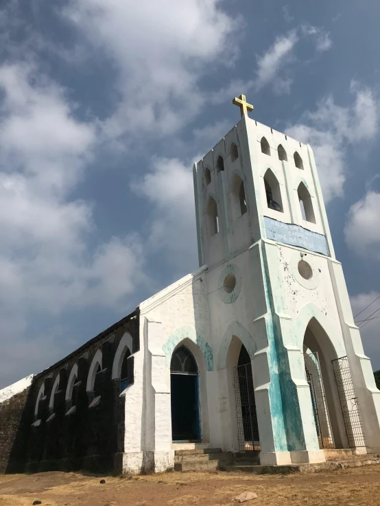 the small, church building stands in front of a cloudy sky