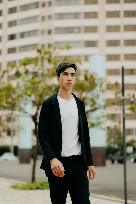 a young man in a suit is walking down the street