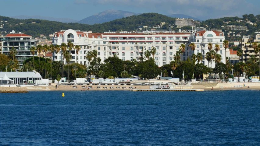 the beach front in front of some tall white buildings