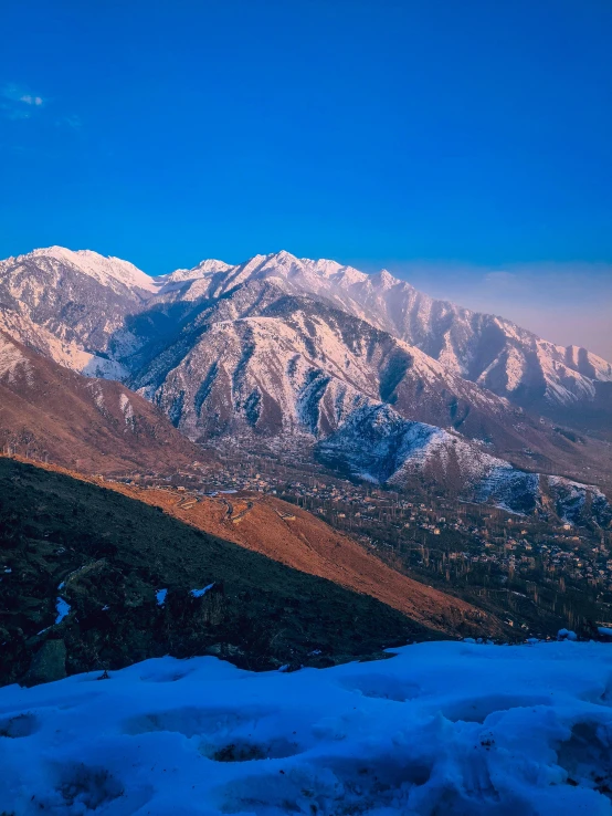 the mountain range at dusk with snow covering it