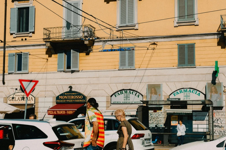 two men crossing a busy street in front of some old buildings