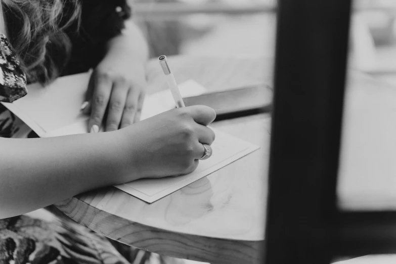 the woman is writing on her notepad and holding a pen