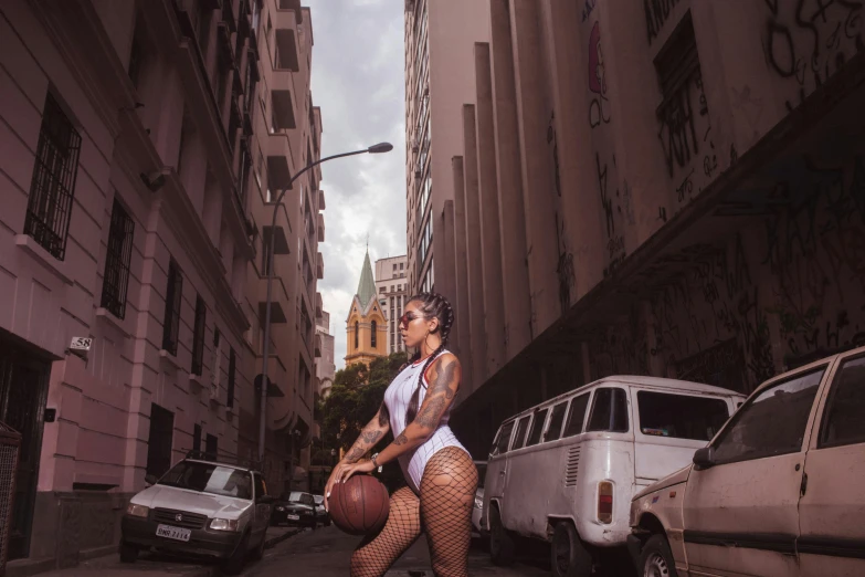 a woman with a basketball on a city street