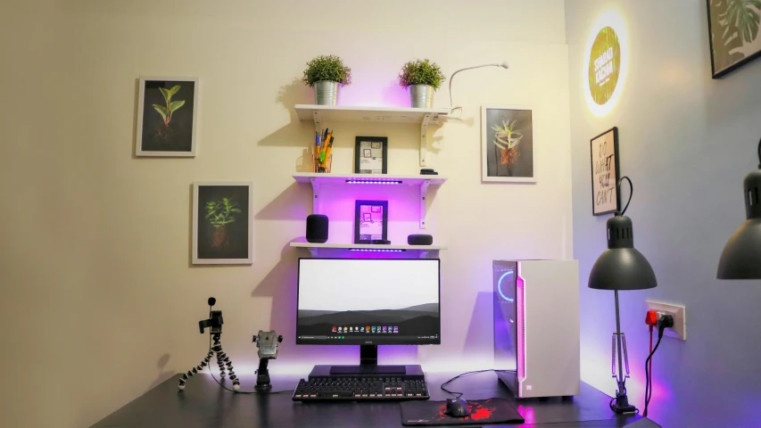 a computer sits on a desk with purple lights