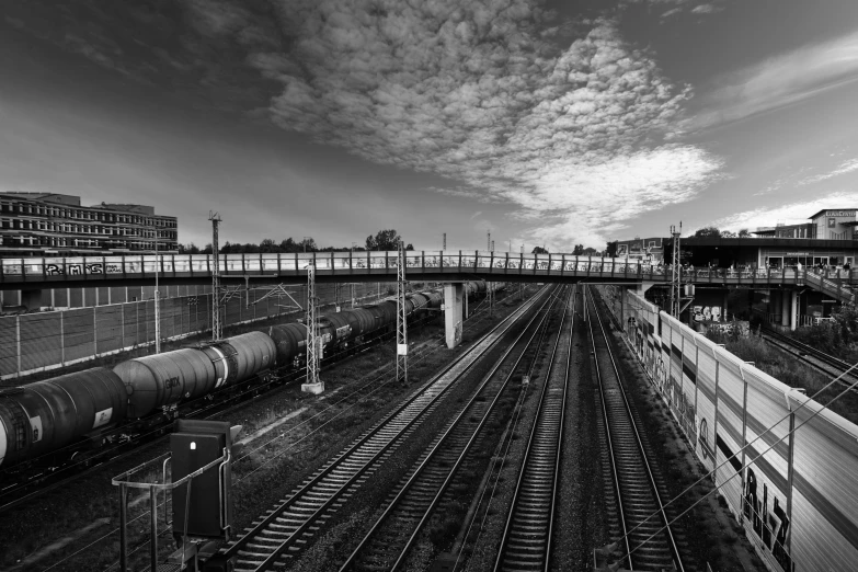 two trains on railroad tracks in front of a cityscape